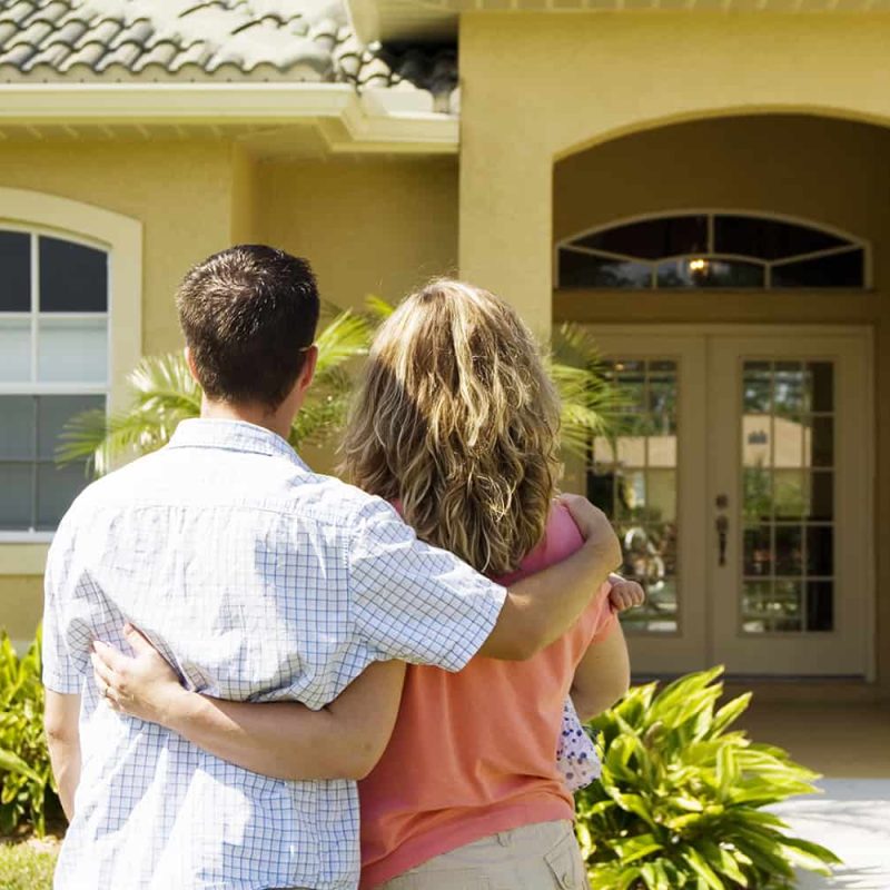 FL couple in front of new house